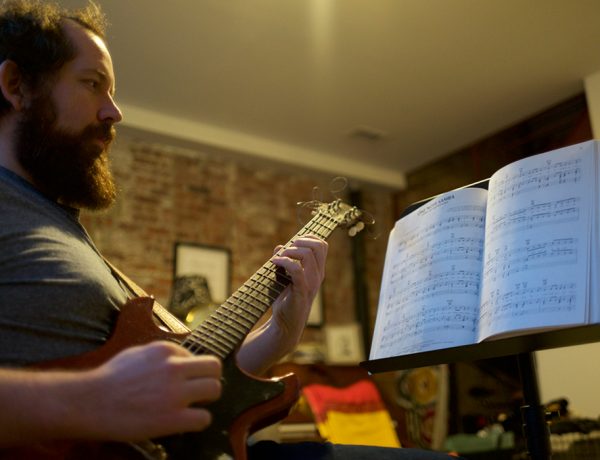 man learning music on guitar