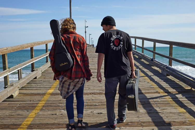 two musicians walking on pier