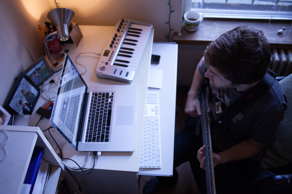 man playing bass with laptop