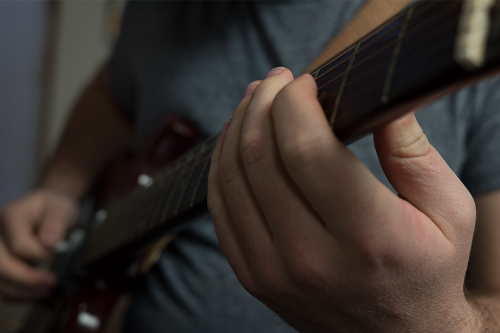 closeup of hands on guitar fret