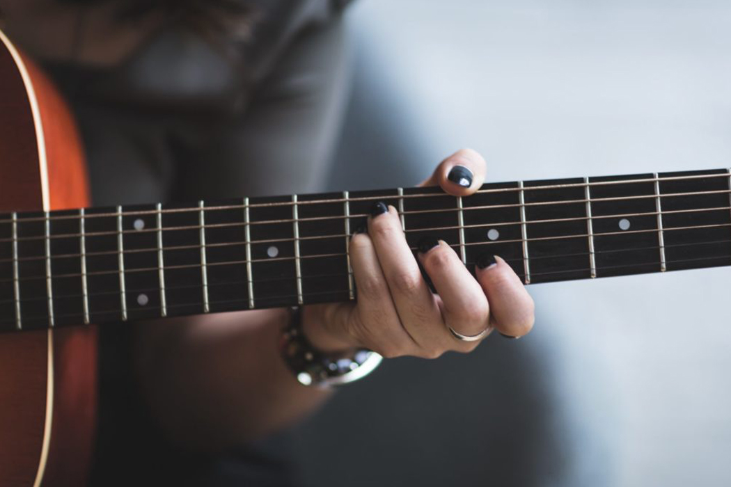 closeup of hand on guitar fretboard