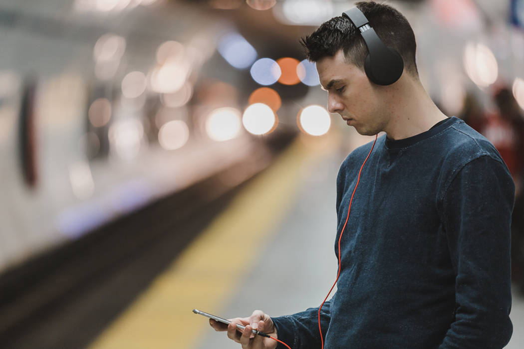 Man in subway listening to music on phone