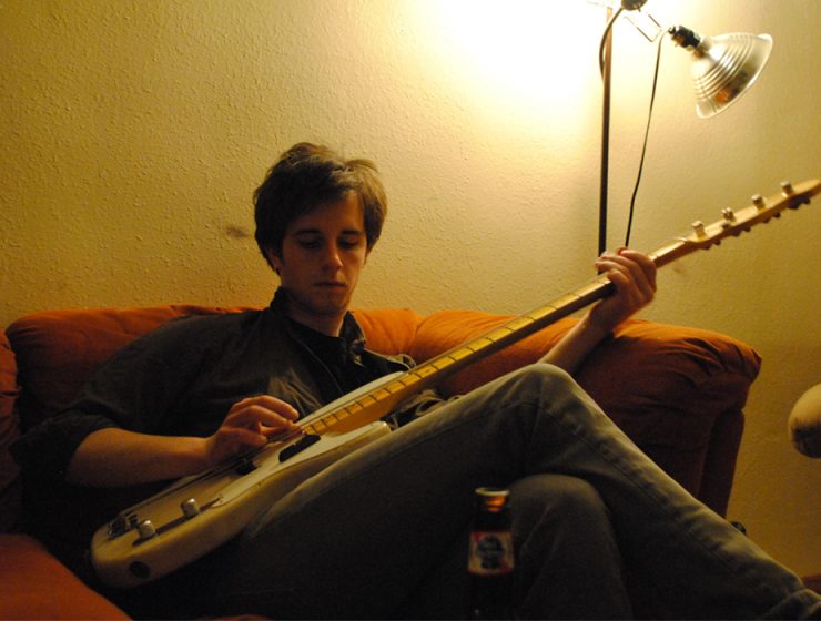 guitarist practicing on a couch backstage