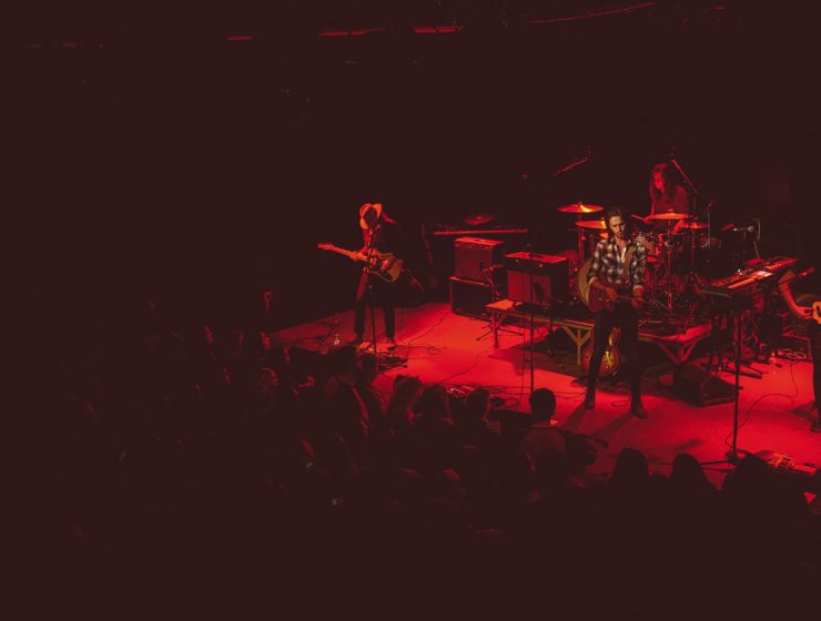 band playing on stage under red lights