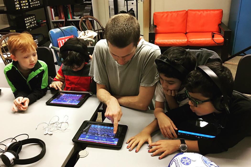Children working with a tech coach at SAFA!'s music lab.