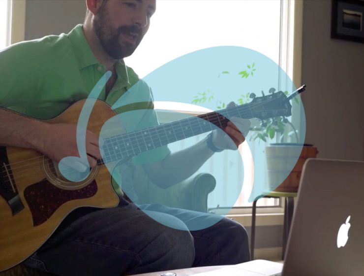 man playing guitar learning on laptop, with Soundfly logo