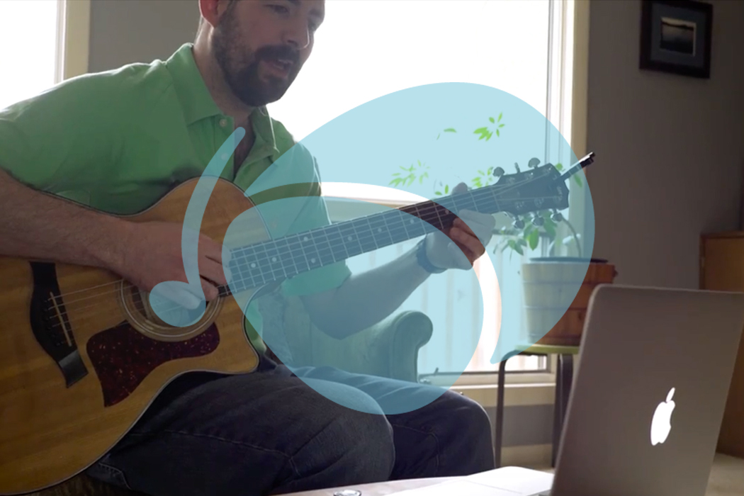 man playing guitar learning on laptop, with Soundfly logo