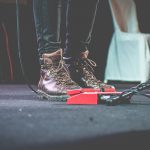 musician's feet on stage near pedals