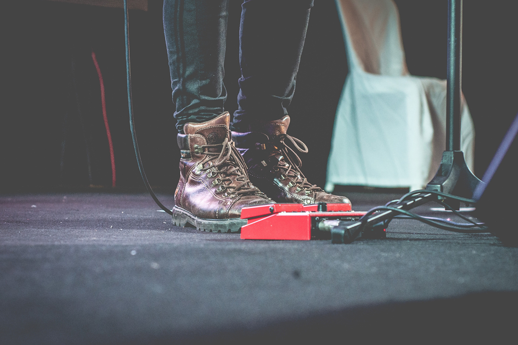 musician's feet on stage near pedals