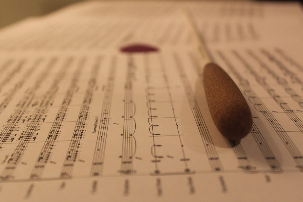 closeup of conductor baton on sheet music