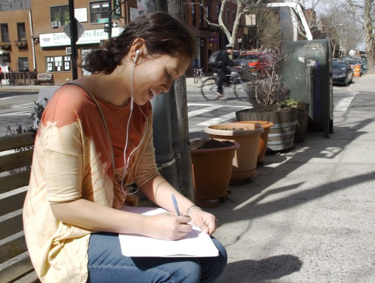 girl writing lyrics on the street