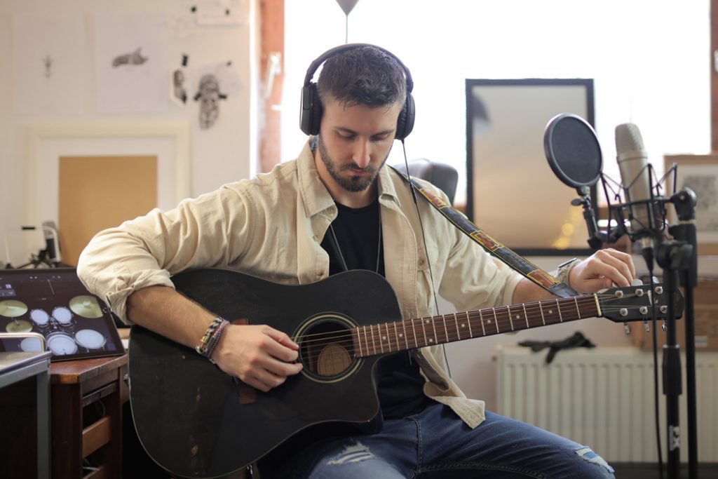 man recording acoustic guitar