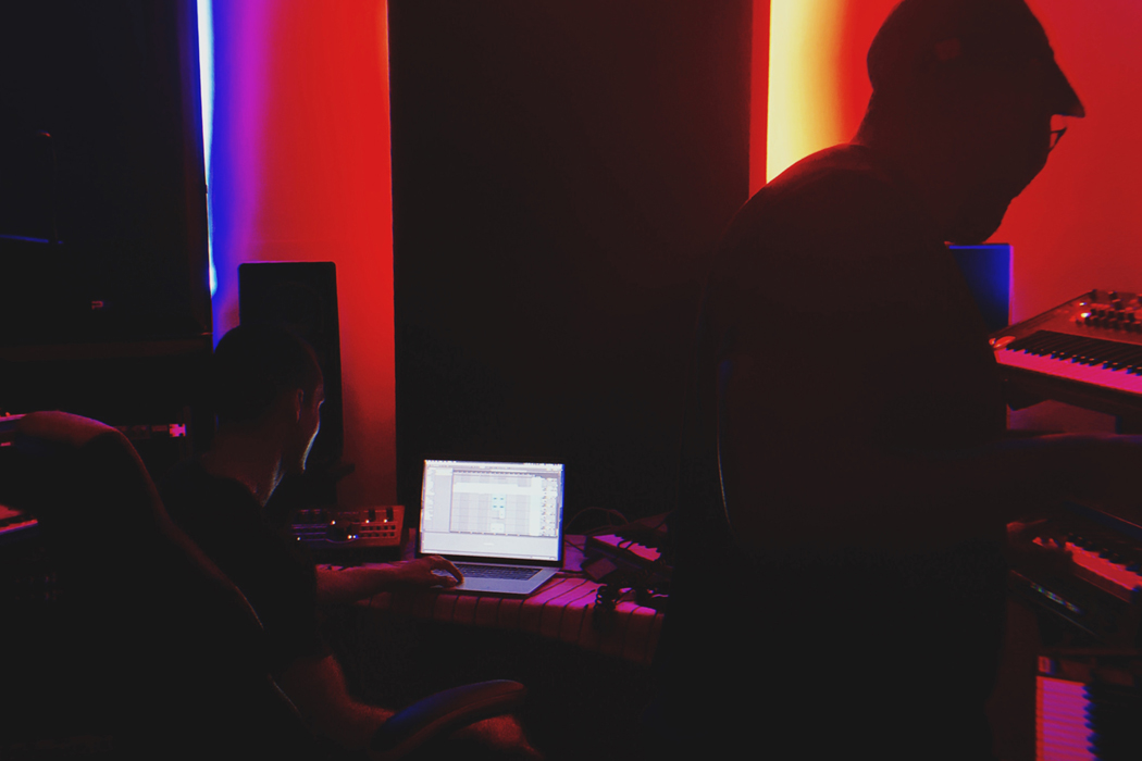 two artists in dark studio