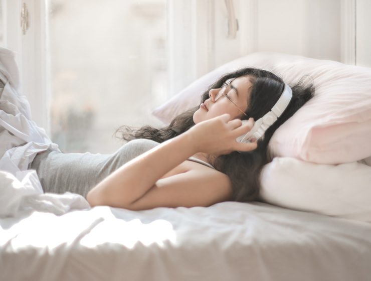 girl in bed listening to music