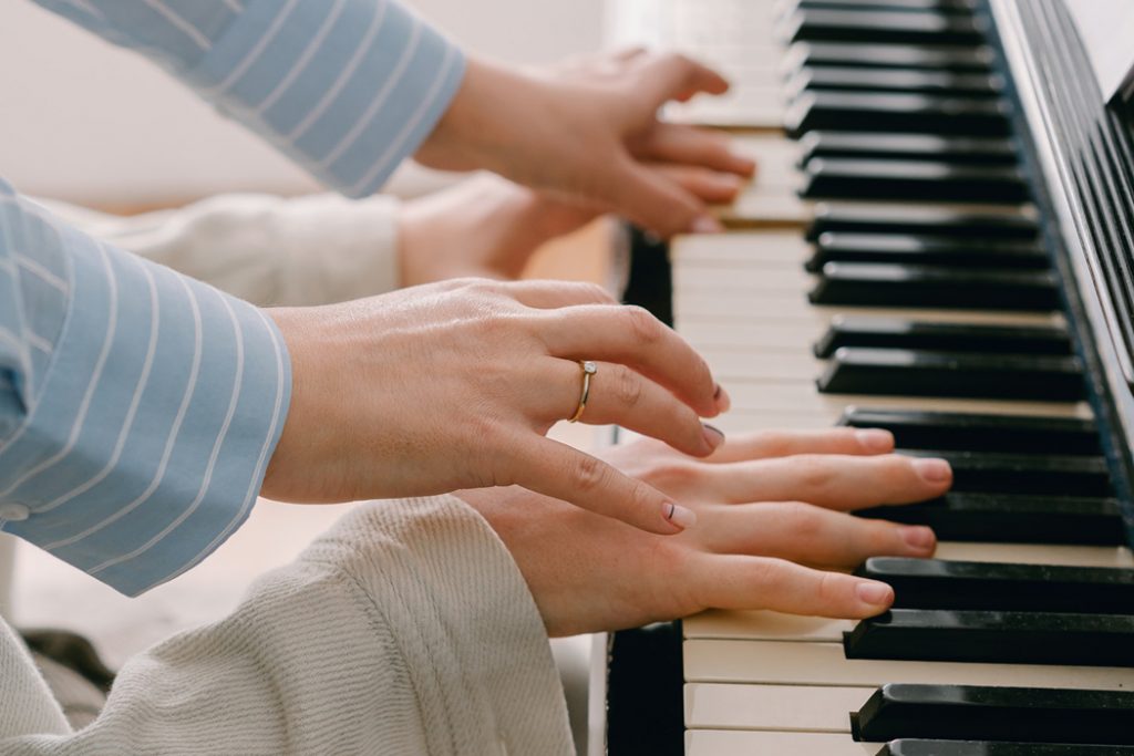 four hands playing piano