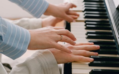 four hands playing piano