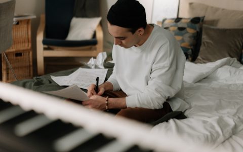 man writing music at home