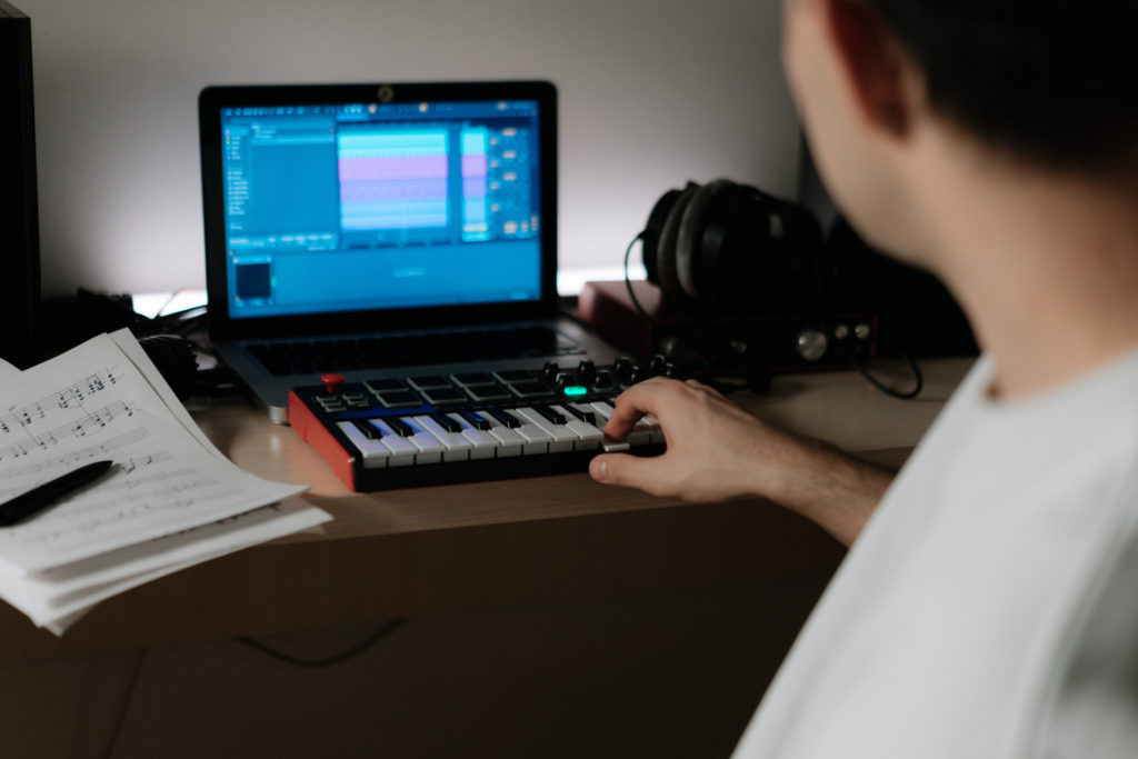 man with midi keyboard at home studio