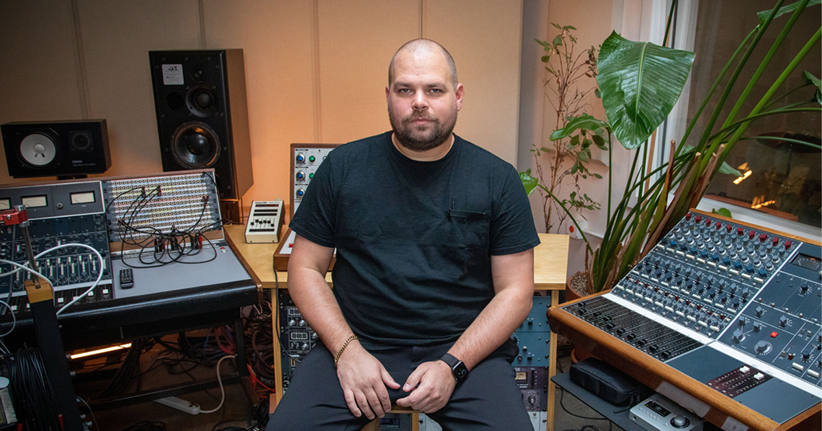 Com Truise in the studio surrounded by gear