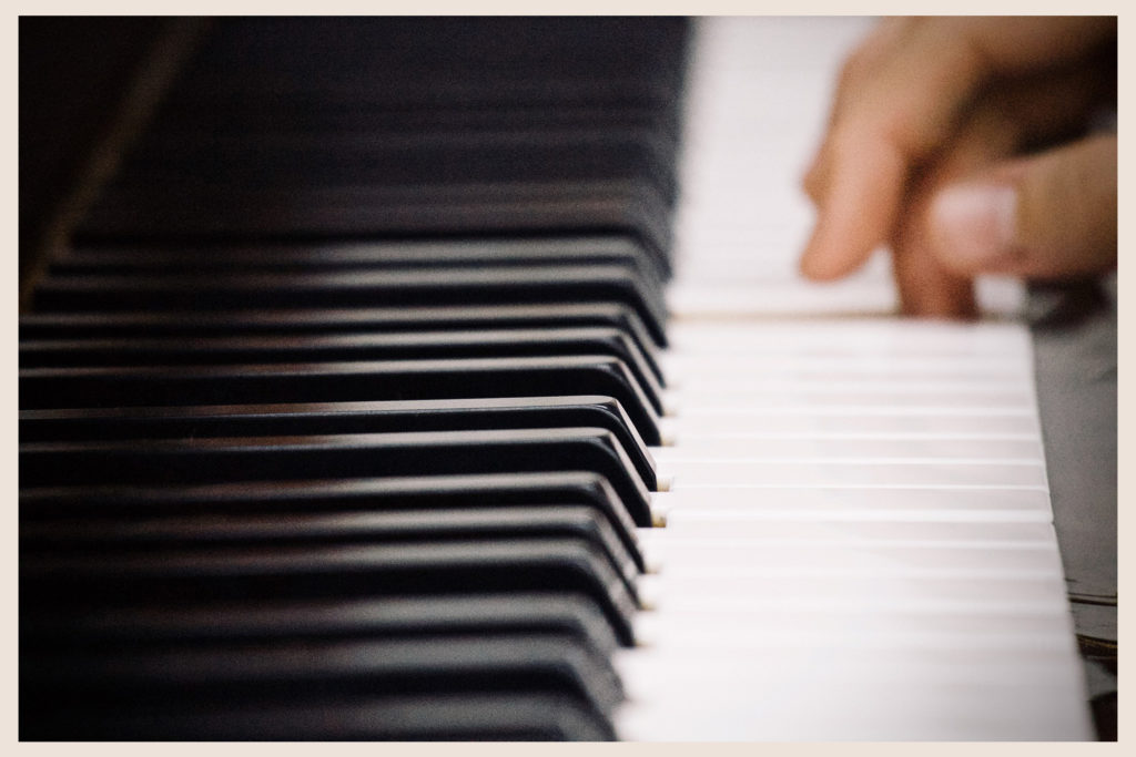 closeup hand on piano keys