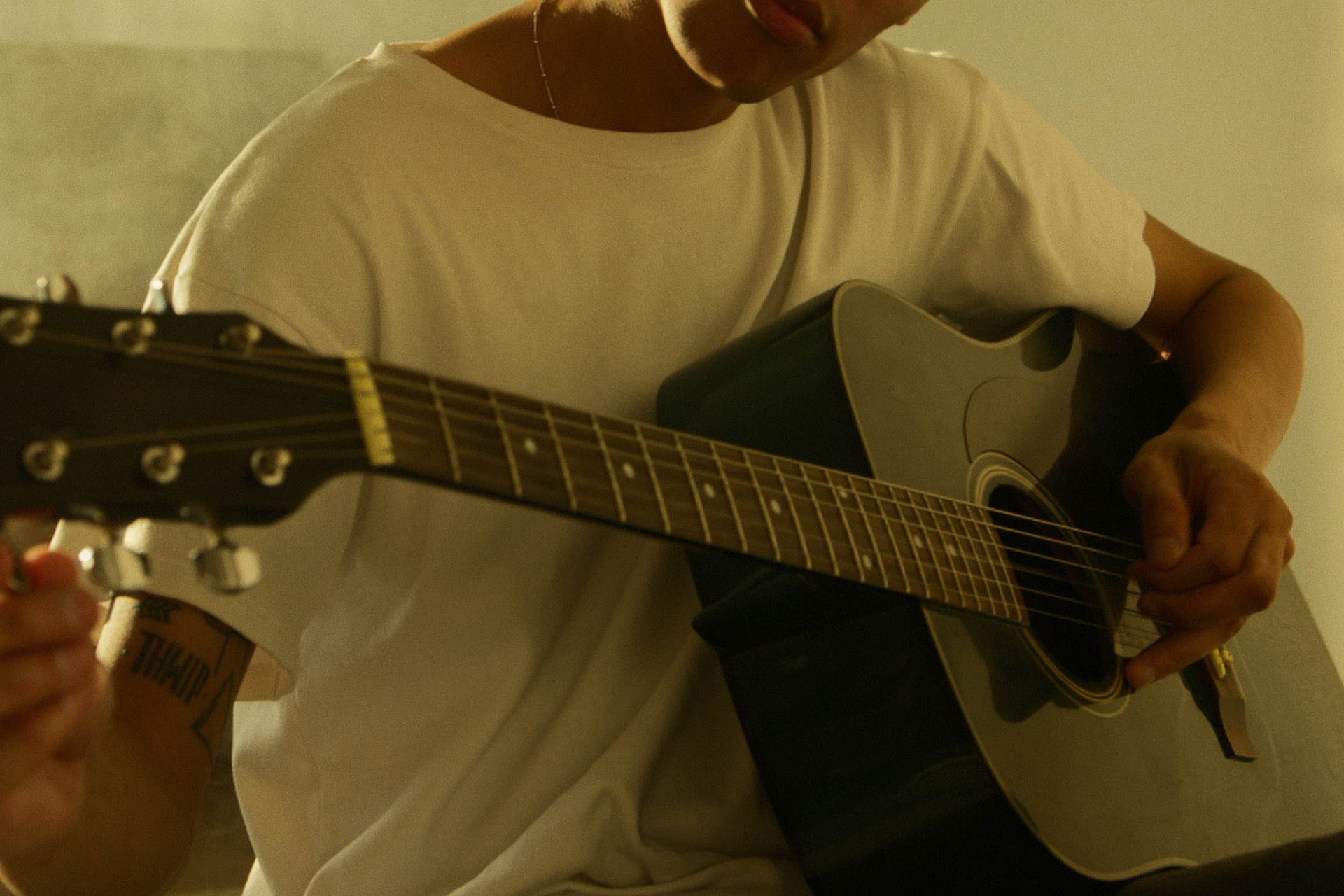 man practicing guitar at home
