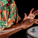 closeup of musician's hands hitting drum