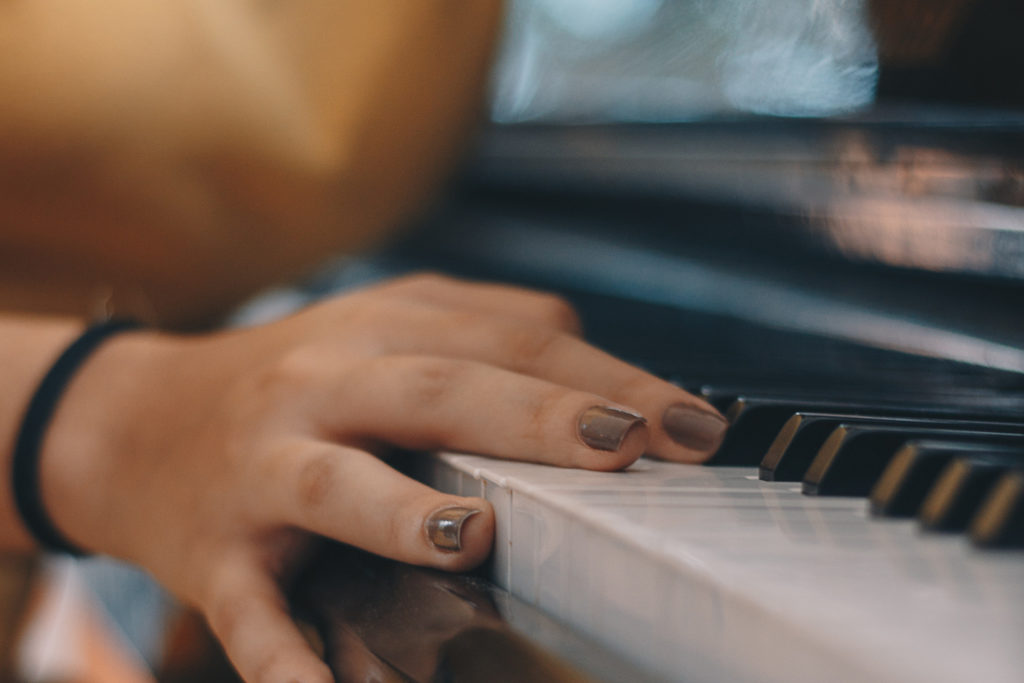 closeup photo of hand on piano