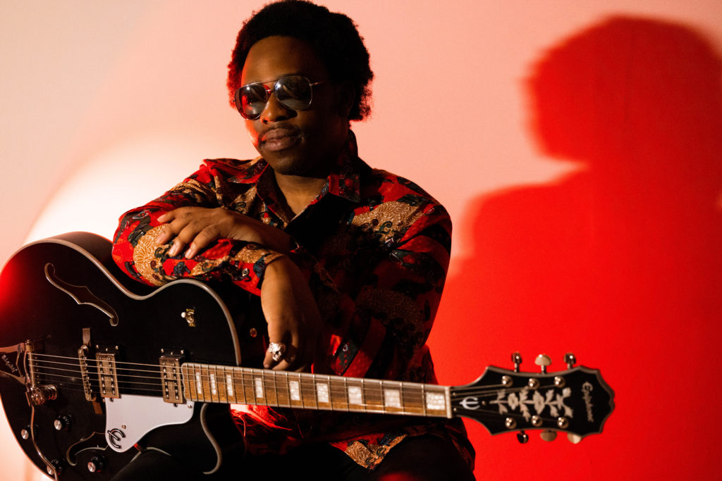 Samson Afolabi holding a guitar