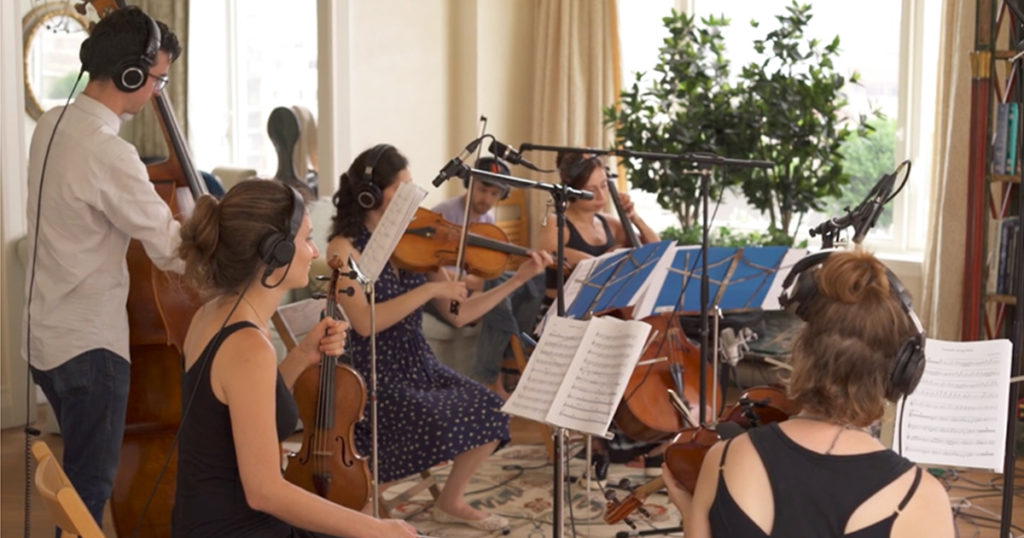 string quintet playing music in a living room