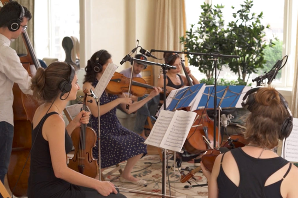 string quintet playing music in a living room