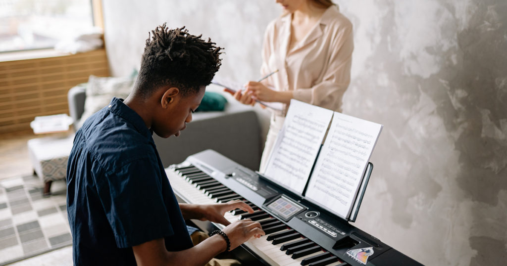 piano teacher giving music lessons
