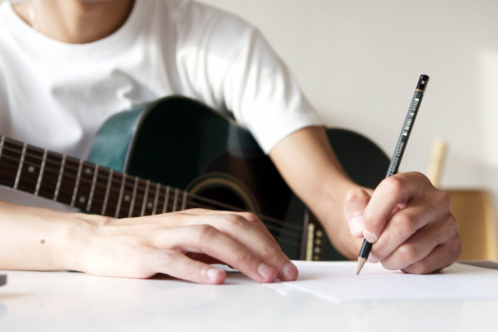 closeup of guitarist writing on paper